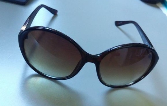 Brown sunglasses on grey surface.